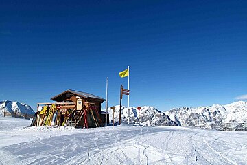 A yellow flag is flying over a snowy mountain
