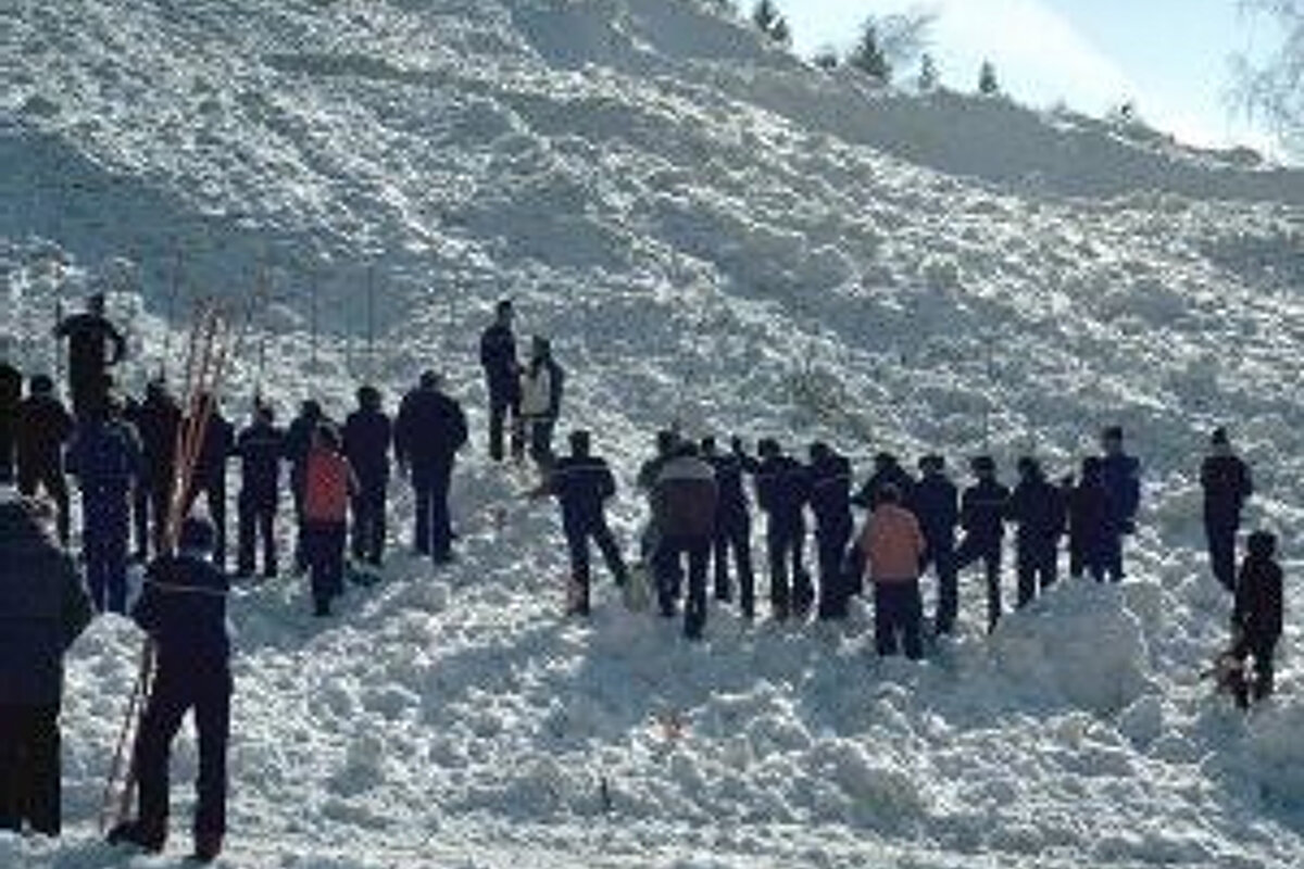 A group of people are standing on top of a snow covered hill