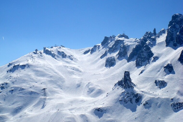 A snowy mountain with a blue sky in the background