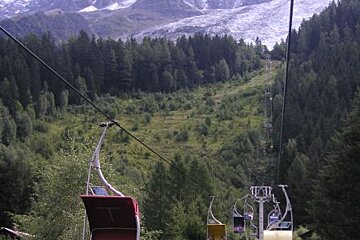 A ski lift going up a hill with a mountain in the background