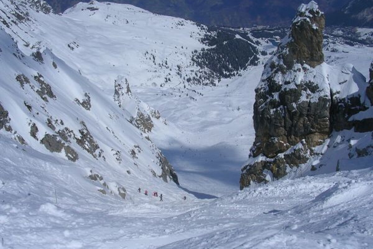 A group of people skiing down a snow covered slope