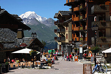 A group of people sit at tables in front of a sign that says ' montagne ' on it