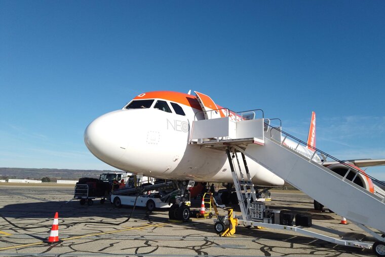 A neo airplane sits on the tarmac at an airport