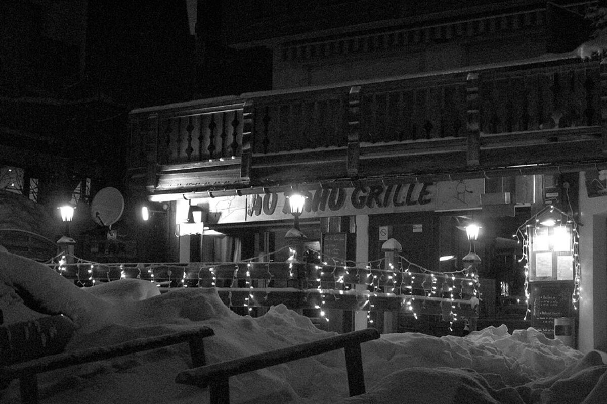 A black and white photo of a restaurant with a sign that says 