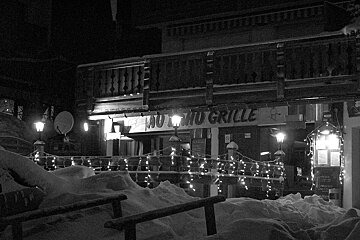A black and white photo of a restaurant with a sign that says