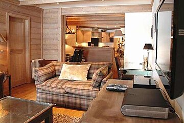 an image of a room with a TV on the wall and a check patterned armchair