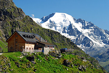 A mountain with snow on it and a house in the foreground