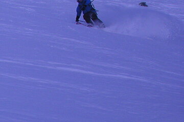 A person riding skis down a snowy hill
