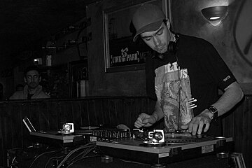A man wearing a linkin park shirt is playing music