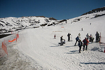 Skiers on a snowy slope with a sign that says ' a ' on it