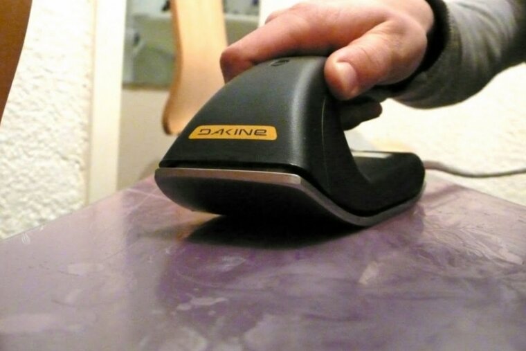 Close up of someone waxing a snowboard