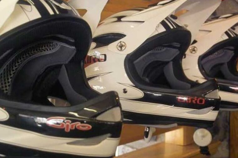 An image of a row of mountain bike helmets on a shelf