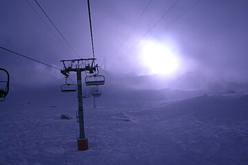 A ski lift with a purple sky in the background