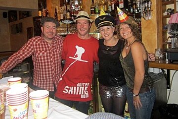 Four people in a bar, posing for photo
