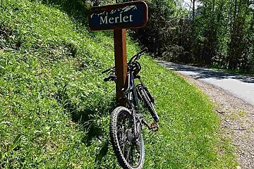 an image of a mountain bike resting against a sign post