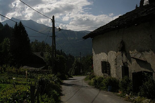 A road with mountains in the background and a building with a sign that says ' a ' on it