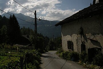 A road with mountains in the background and a building with a sign that says ' a ' on it