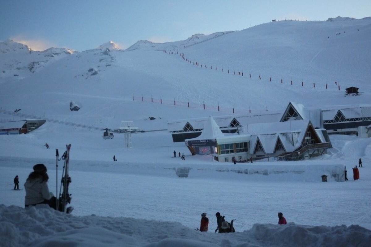 an image of a skier sitting and enjoying the view with a rare bit of blue sky