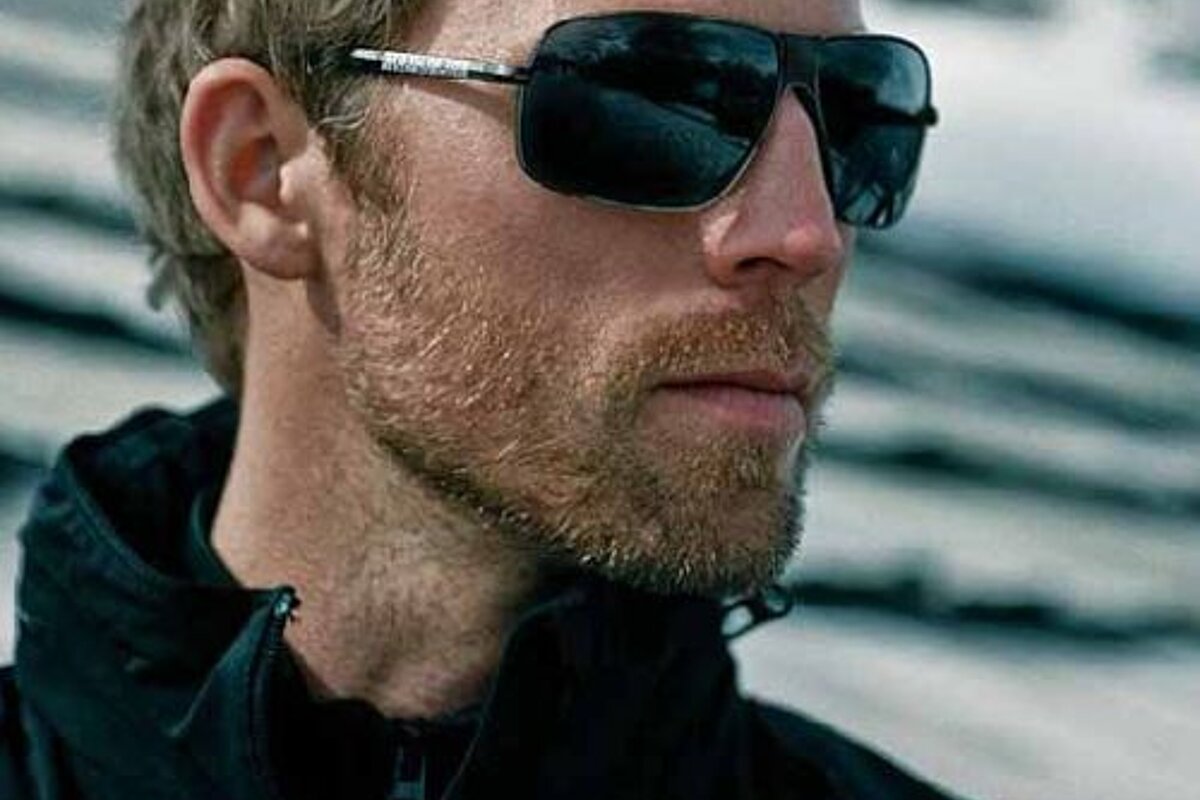 A close up of a man wearing sunglasses and a jacket