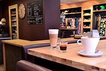 an image of a bench table with a couple of coffee mugs on it and skis behind