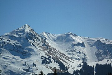 A snowy mountain with a blue sky in the background