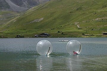 an image of a girl in a plastic ball on a lake