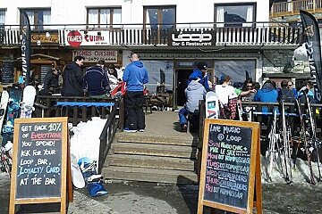 A group of people are gathered outside a restaurant called loop bar & restaurant