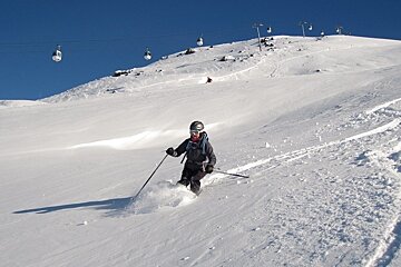 skier in powder with blue sky