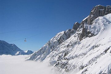 A ski lift going up a snow covered mountain