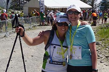 Two women are posing for a picture together at a race