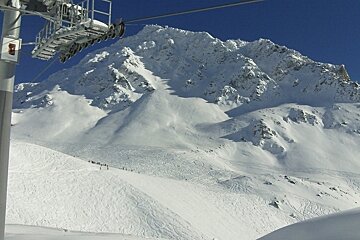 Ski lift and mountains and piste in distance