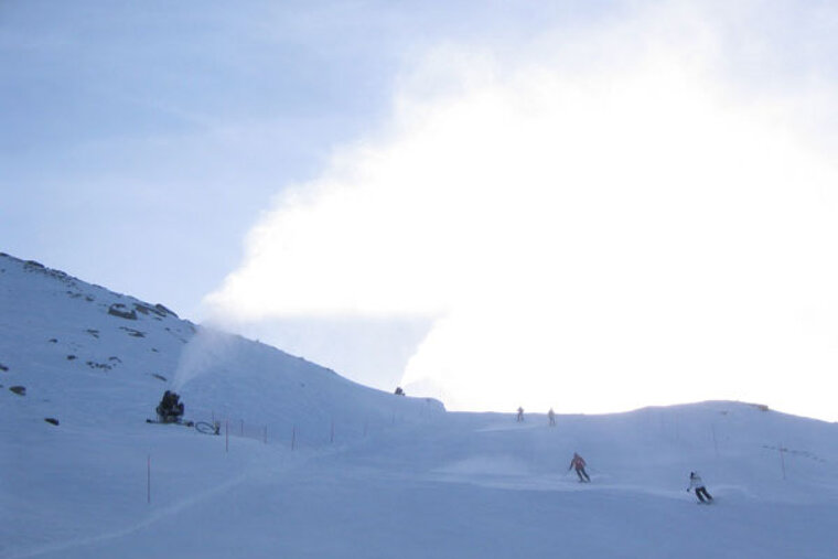 A group of people skiing down a snow covered slope