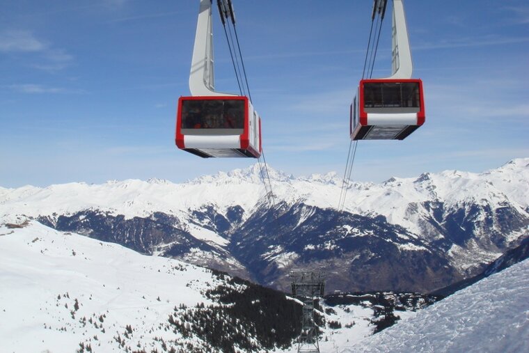 A ski lift is going up a snowy mountain
