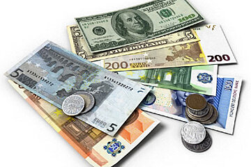 A pile of foreign currency including a five dollar bill