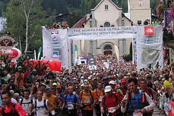 A large group of people are running in front of a banner that says the north face ultra trail