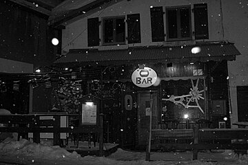 A black and white photo of a bar in the snow