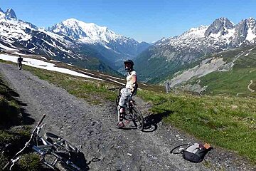an image of a woman on a mountain bike at the head of a trail