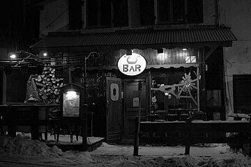 A black and white photo of a bar in the snow