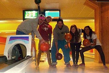 A group of people holding bowling balls in a bowling alley