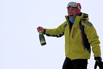 An image of a happy skier with a champagne bottle