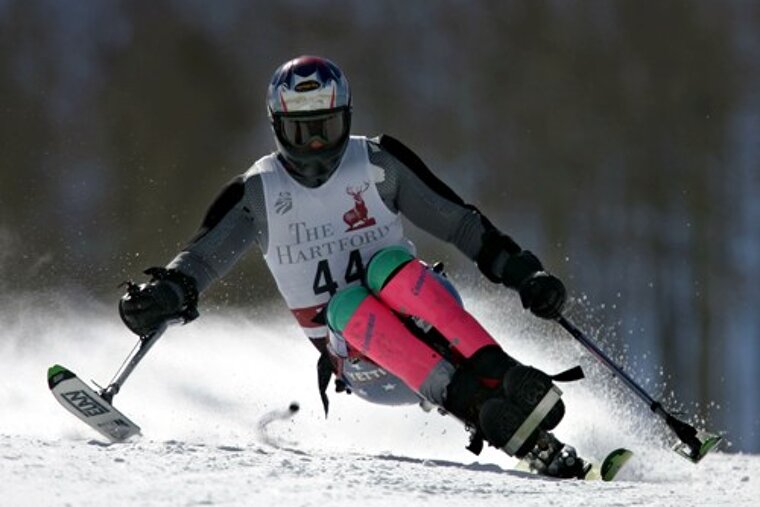 A person skiing down a snowy slope with the hartford logo on their shirt