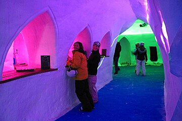 People standing in a tunnel with purple and blue lights