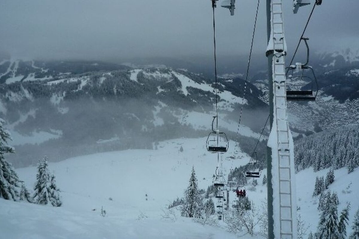 A ski lift going up a snow covered mountain