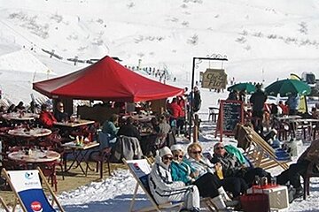 A group of people are sitting under a tent with a sign that says chez ritz