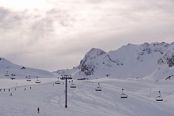 A ski lift going up a snow covered mountain