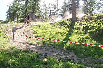 A person riding a bike on a trail with trees in the background