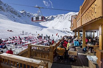 An image of the terrace, deckchairs, pistes and cable car at Restaurant Les Verdons, Courchevel 1850