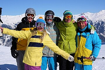 An image of a group of smiling skiers/boarders