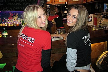 Two girls posing for a photo at the bar in the Farinet