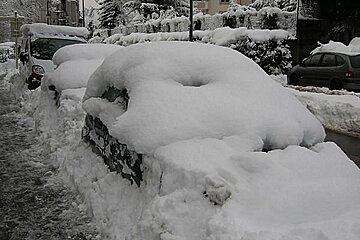 A row of cars are covered in snow including one that says renault
